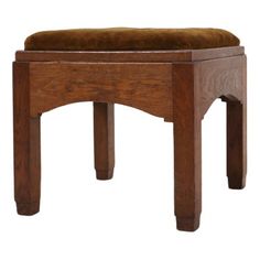 a wooden stool with a brown cushion on top