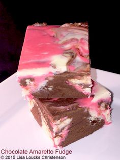 two pieces of chocolate fudge cake on a white plate with pink and brown icing