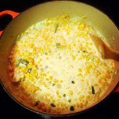 a pot filled with corn and cheese on top of a stove