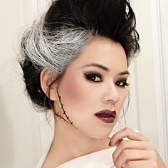 a woman with grey hair and makeup is posing for the camera