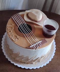 a birthday cake with a guitar, hat and wine glass on the bottom layer that says happy birthday