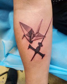 a tattoo on the leg of a person with two origami cranes