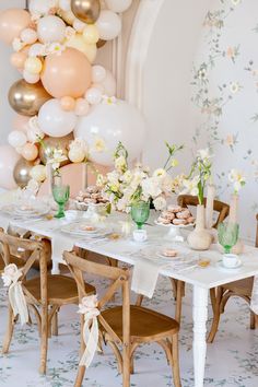 a table set up with balloons and desserts