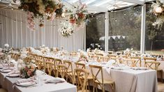 the tables are set with white linens and floral centerpieces for an elegant wedding reception