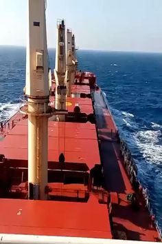 a large red ship in the middle of the ocean with lots of water around it