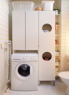 a washer and dryer in a small room with yellow tiles on the walls