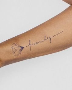 a woman's arm with a tattoo that says family on it and a flower