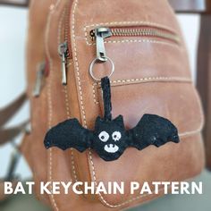 a bat keychain hanging from a brown leather bag with the words bat keychain pattern on it