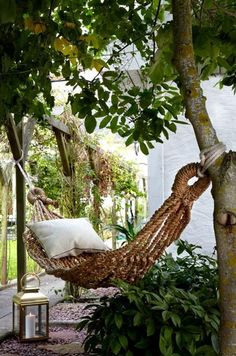 a hammock hanging from a tree next to a lamp