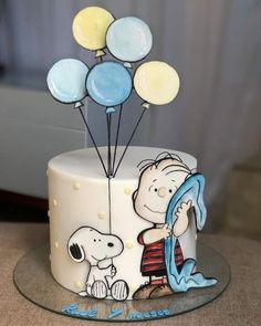 a birthday cake decorated with balloons and a cartoon character