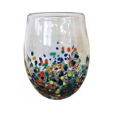 a wine glass with multicolored dots on the rim and bottom, sitting against a white background