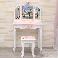 a white vanity table with a mirror and stool