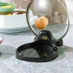 a magnifying glass sitting on top of a counter next to bowls and spoons