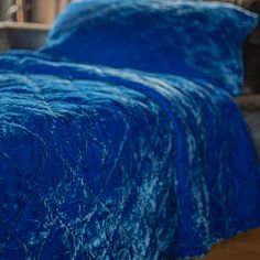 a blue bedspread on a bed in a room