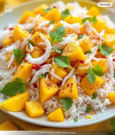 a white plate topped with rice covered in mangos and cilantro next to green garnish