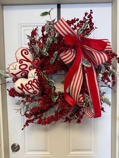 a red and white christmas wreath on a door