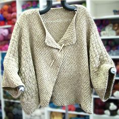 a sweater hanging on a rack in front of shelves with stuffed animals and other items