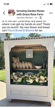 an outdoor garden stand with flowers and bread