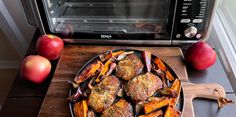 a pan filled with food sitting on top of a wooden cutting board next to an oven