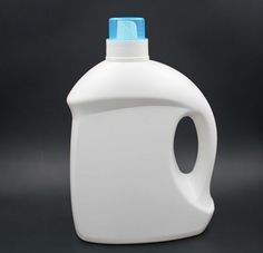 a gallon of white liquid with blue cap on the top sitting on a black surface