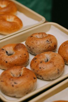 four trays filled with bagels sitting on top of a table