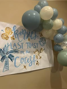 some balloons are hanging on the wall and there is a sign that says renries last toast on the coast