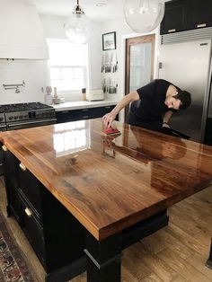 a man in black shirt standing on top of a wooden counter