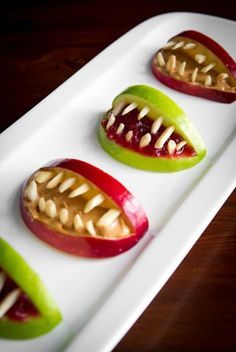 four apples with teeth on them sitting on a white plate