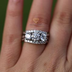 a woman's hand with two diamond rings on top of her ring and the middle finger