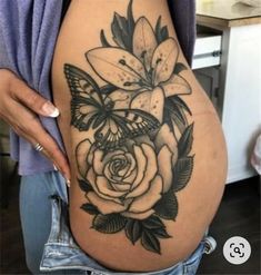 a pregnant woman's stomach with flowers and butterflies tattooed on the side by her belly