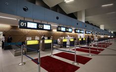 an airport terminal with red carpet and blue walls