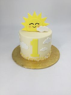 a white cake with yellow frosting and a smiling sun on top