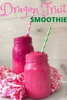 two pink smoothies in mason jars with green and white straws on the side