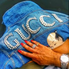 a woman's hand resting on the back of a jean jacket