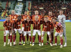 a group of men standing on top of a soccer field