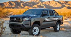 a gray truck parked in the desert with mountains in the background