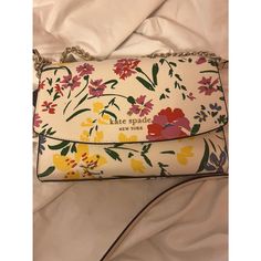 Beautiful Kate Spade Garden Bouquet Handbag Purse, A Colorful Addition To Your Wardrobe. This Rectangular Crossbody Bag Features A Beautiful Floral Pattern With Accents Of Butterflies, Adding A Whimsical Touch To Any Outfit. The Bag Has A Magnetic Snap Closure And A Detachable Strap For Convenience. The Light Gold Hardware And Cream White Handle/Strap Add A Touch Of Sophistication To The Bag. This Small-Sized Bag Is Perfect For Various Occasions, Including Travel, Weddings, Parties, And Workwear Luxury Multicolor Floral Print Bags, Luxury White Bags With Floral Print, Multicolor Floral Print Top Handle Bag, Elegant Floral Print Crossbody Shoulder Bag, Elegant Floral Print Top Handle Shoulder Bag, Elegant Floral Print Shoulder Bag For Spring, Spring Floral Print Crossbody Bag, Elegant Top Handle Bag With Floral Print, Spring Floral Print Cream Bags