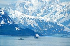 a cruise ship is in the water with mountains in the backgrounnds