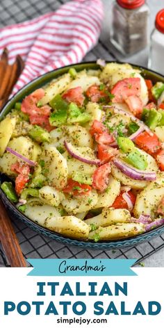 an italian potato salad with tomatoes and onions in a blue bowl