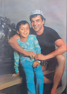 a man sitting next to a little boy on a bench