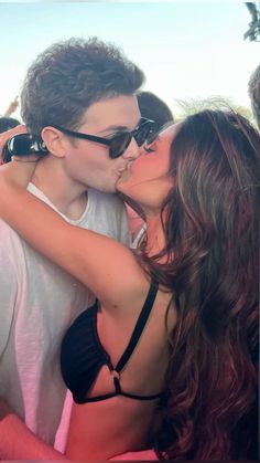 a man and woman kissing each other in front of a crowd at a music festival