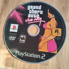 there is a video game disc on the floor with it's cover pulled up