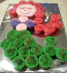 some cupcakes are sitting on top of tin foil with green and red icing