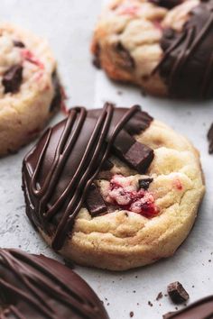 cookies with chocolate and strawberries are sitting on a baking sheet, ready to be eaten