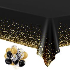 a black table cloth with gold and white confetti on it next to balloons