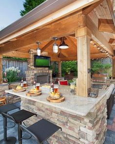 an outdoor kitchen with stone counter tops and grilling area