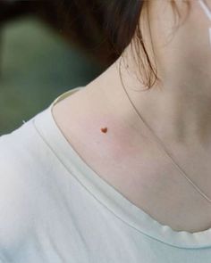 a woman with a heart tattoo on her neck