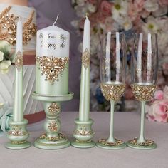 a table topped with wine glasses next to a cake and candlesticks on top of each other