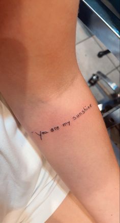 a woman's arm with the words you are my sunshine tattooed on it