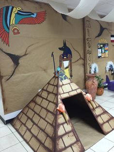 an egyptian themed room is decorated with paper machs and clay pots on the floor